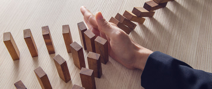 Engaging Third Parties Requires the Ability to Manage Risk A persons hand stops dominoes from falling