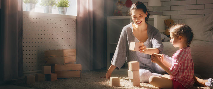 Mother and child playing with blocks on floor