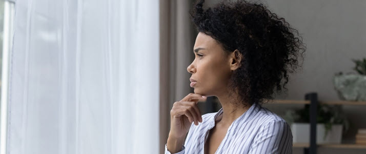 Black business woman considering future of her payroll team Black business woman at window considering future of her payroll team