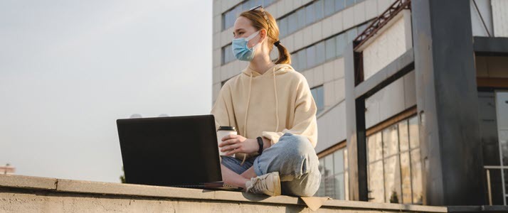 Young woman of Gen Z age works outside with laptop and coffee Young woman of Gen Z age works outside with laptop and coffee