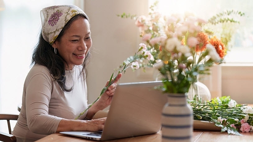 mature female business owner looks at laptop computer mature female business owner looks at laptop computer