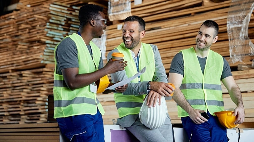 happy coworkers taking coffee break at lumber yard warehouse happy coworkers taking coffee break at lumber yard warehouse