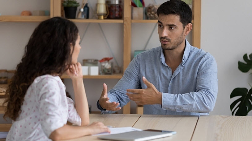 Latino male company manager interviews employee about compliant Latino male company manager interviews employee about compliant