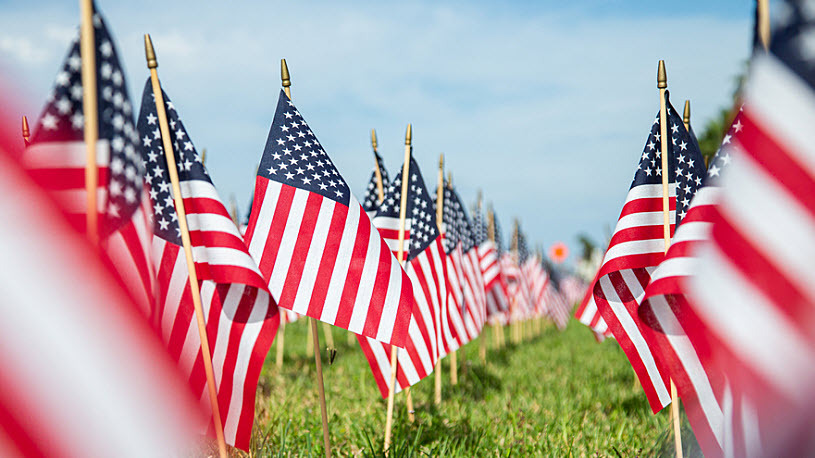 Photo of hundreds of American flags on a grassy field Photo of hundreds of American flags on a grassy field