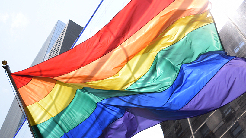 A rainbow Pride flag waving in the wind.