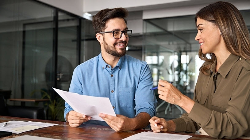 Female health insurance broker advises male small business owner Female health insurance broker advises male small business owner