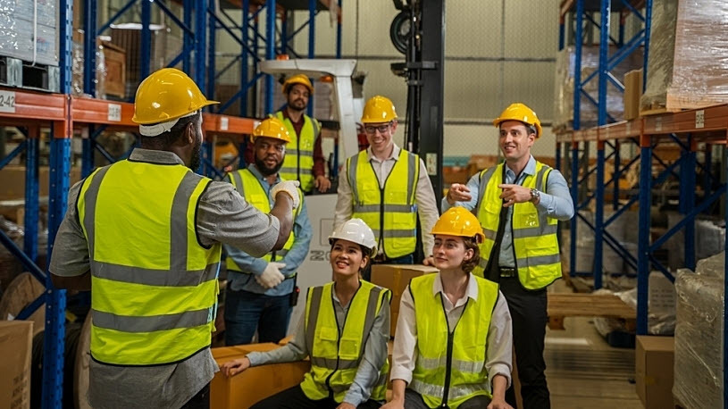 A group of diverse warehouse workers meeting with team leader A group of diverse warehouse workers meeting with team leader
