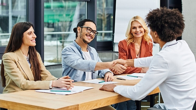 An interview panel greets job applicant across table An interview panel greets job applicant across table