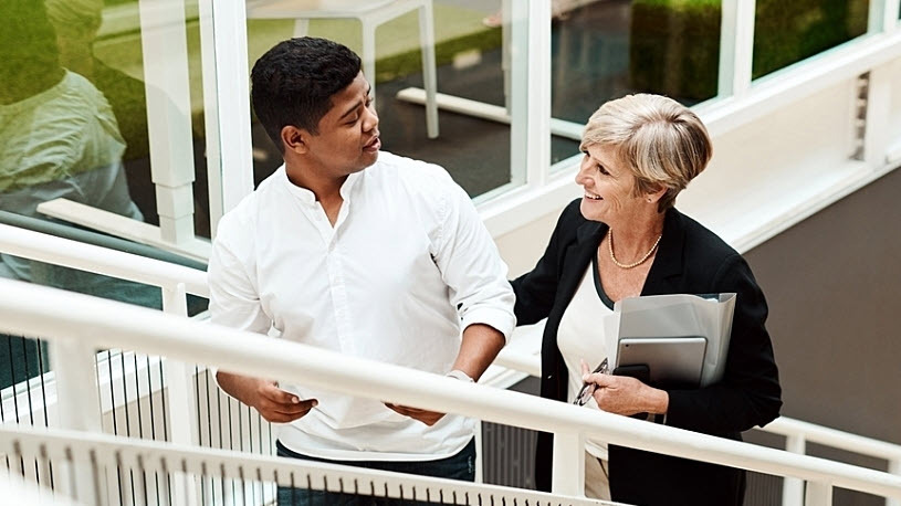 Employee talks to senior manager while walking up stairs Accelerate Your Career Mobility Initiatives by Breaking Down Systemic Barriers