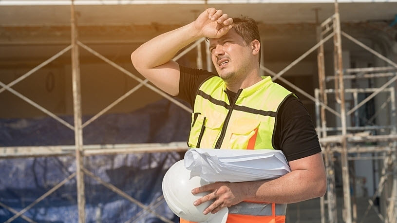 Male construction engineer wipes brow working outside in the sun Employer Responsibilities for Protecting Employees from the Heat