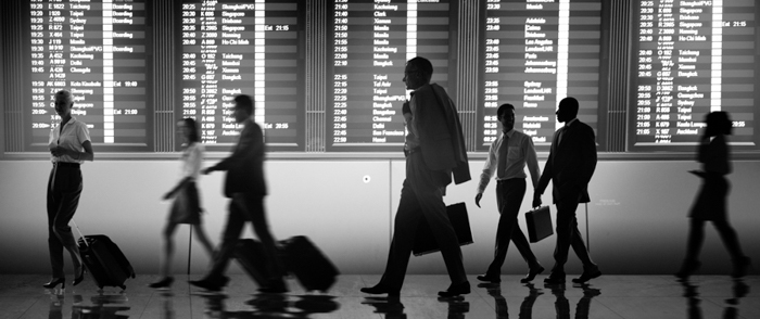 How Work Culture Norms Cross Country Lines A group of executives walk past a departures board.