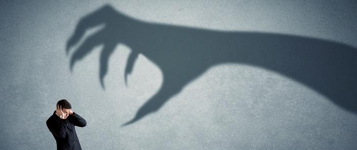 Shadow Banking A large shadowy hand reaches for a businessman.